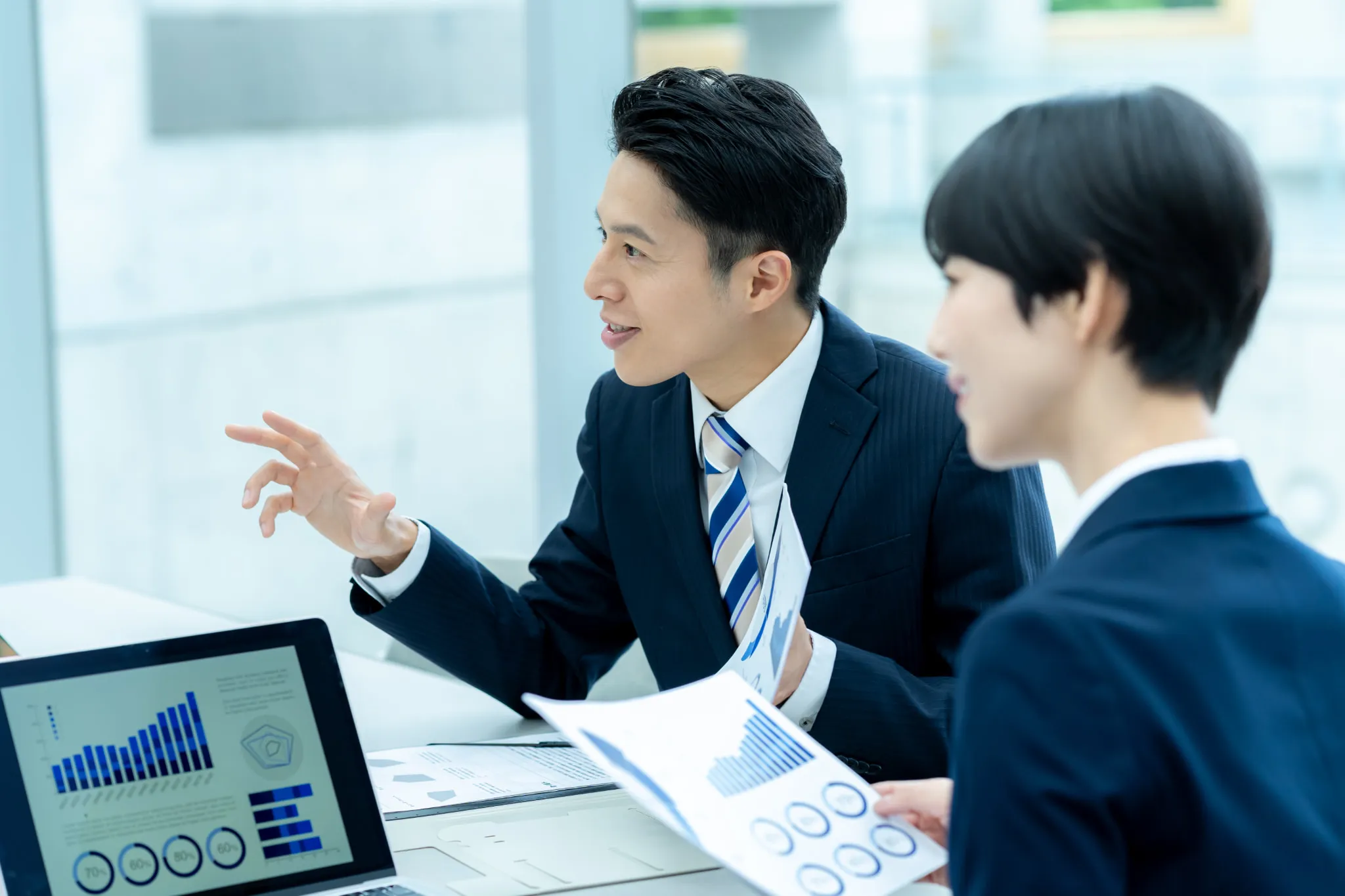 ミーティングで握手するビジネスパーソン